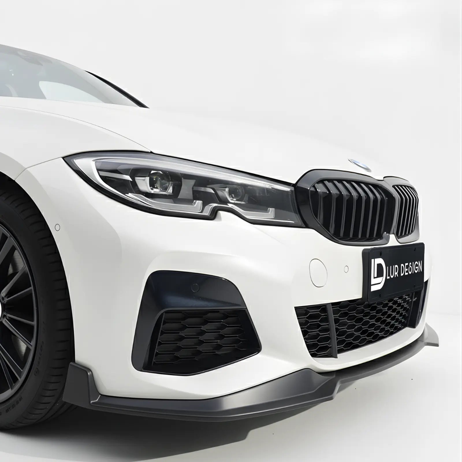 Front Lip splitter for BMW Series 3 G20 1 Close-up of a white car's front grille with a black grille and visible branding on a white background.