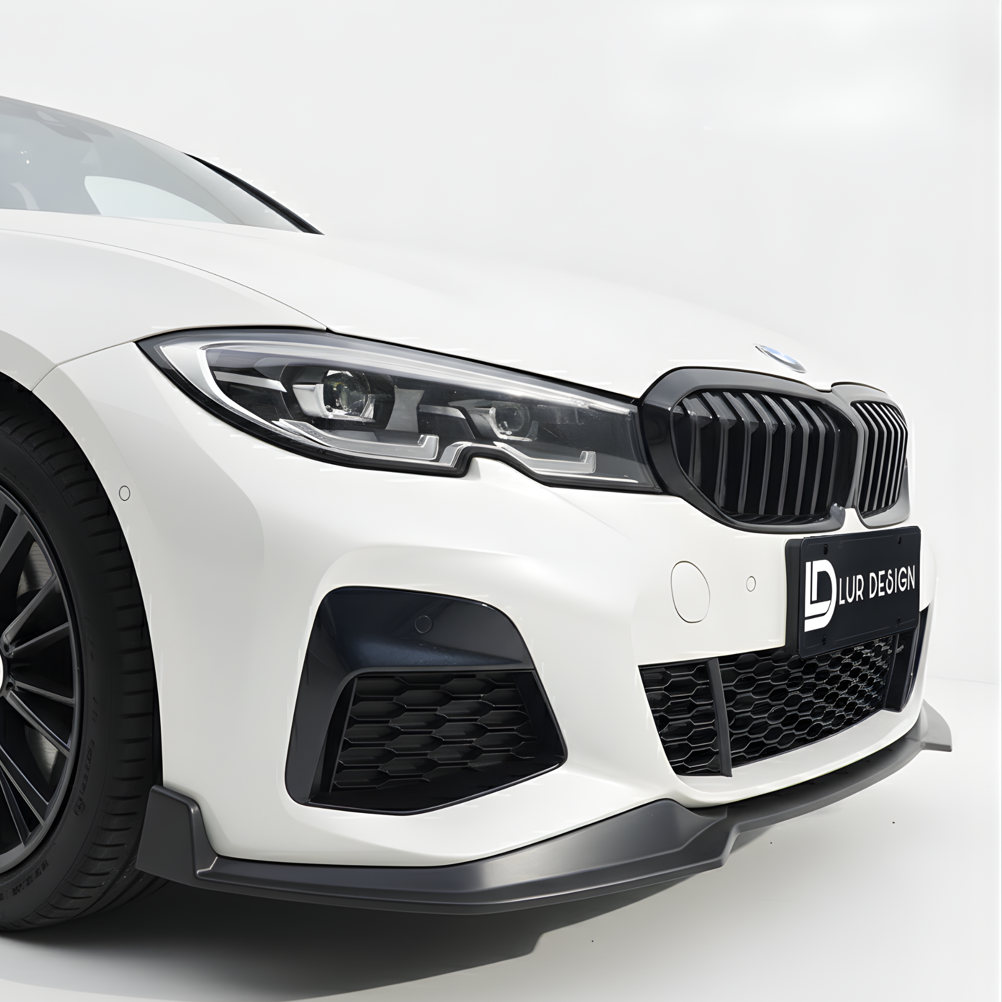 Front Lip splitter for BMW Series 3 G20 1 Close-up of a white car's front grille with a black grille and visible branding on a white background.